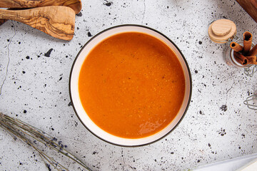 Bowl of lentil puree soup on a light decorated background
