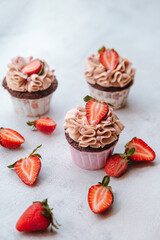 Chocolate strawberry cupcakes on light background