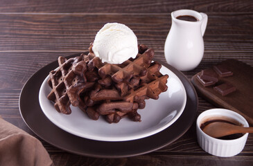 Homemade chocolate waffles with ice cream decorated chocolate syrup.