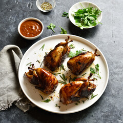 Roasted quails on white plate