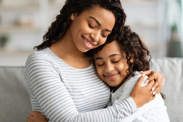 Obraz premium Closeup portrait of hugging african american mother and daughter