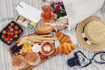 Delicious picnic with strawberries, croissants and appetizers on the board