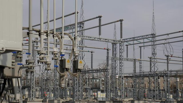 Motion along switchyard with metal supports and power production equipment at contemporary substation close view