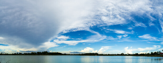 Panorama, blue sky, and large white clouds over the river.
