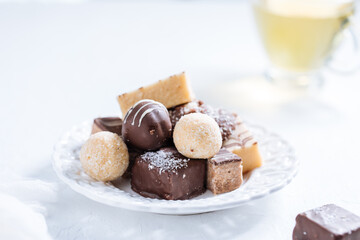 Combination of  sweet bites on a bright background with cup of tea