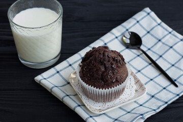 Homemade chocolate muffins or cake with a glass of milk. Place for text. Homemade or bakery pastries for breakfast or celebration. High quality photo