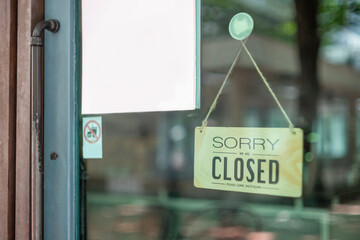 sorry we are closed sign hanging outside a restaurant, store, office or other