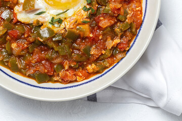 Vegetable dish pisto manchego made of tomatoes, zucchini, peppers, onions with fried egg