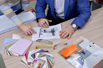 the designer approves the layout of the kitchen set made of laminated MDF. selection of furniture handles for the furniture with the client in the office.