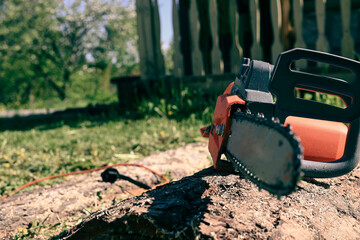 electric saw on a board against a background of greenery