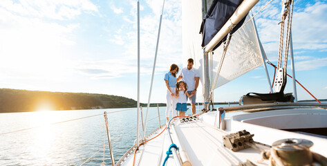 Family Enjoying Yacht Ride Standing On Deck And Holding Hands