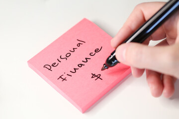Close-up of the Handwriting Title "Personal Fianance" on a Postit paper Note.
