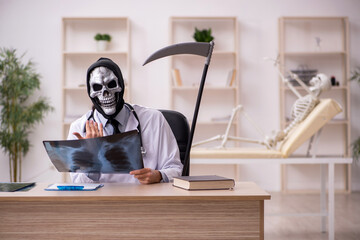 Devil doctor radiologist examining skeleton patient