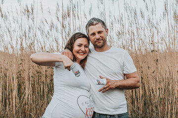 Beautiful young couple expecting a baby. Outdoor photo of happy parents to be.