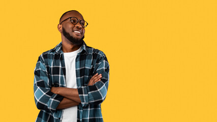 Black Man Posing Crossing Hands Looking Aside On Yellow Background