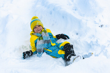 Child playing with snow in winter