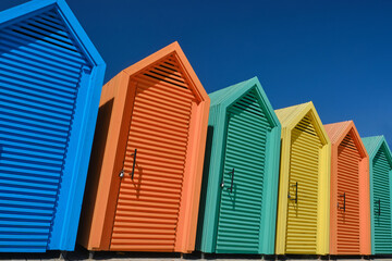 Some colorful beach huts of different colors against the blue sky. Selective focus