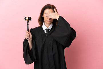 Middle aged judge woman isolated on pink background covering eyes by hands. Do not want to see something - obrazy, fototapety, plakaty