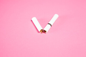 broken cigarette on pink background