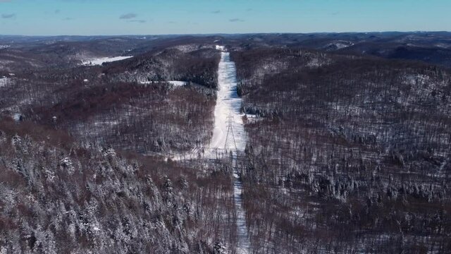 A slow motion drone videography featuring aerial view of modern 4G and 5G telecommunication towers, located in snow and bare trees area