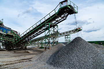 Industrial background - crusher (rock stone crushing machine) at open pit mining and processing plant for crushed stone, sand and gravel