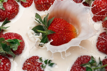 Ripe strawberries fall into the cream. Splashes of milk.
