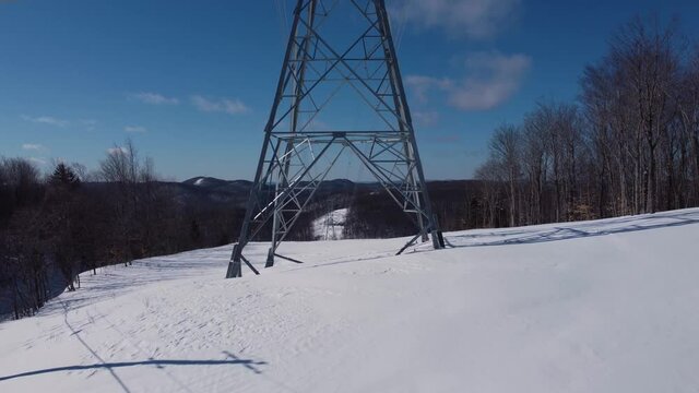 A mesmerizing video zooming in on the base of a cellular communication tower, with the pure white snow in surrounding creating beautiful effect