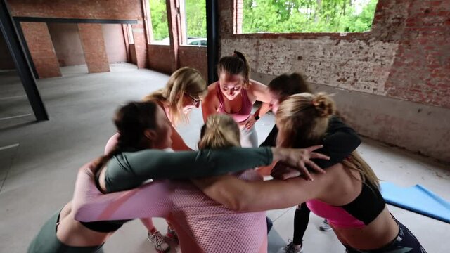 Group or team of happy young sportive women in a gym all cheering with hands up and applauding. High quality FullHD footage