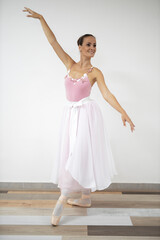 Naklejka premium Beautiful professional ballerina in pink dress dance in ballet studio