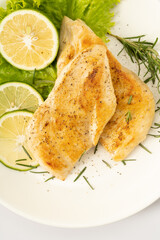 Pan-fried chicken breast on a solid background
