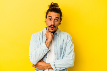 Young caucasian man with long hair isolated on yellow background having some great idea, concept of creativity.