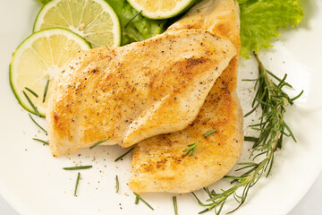Pan-fried chicken breast on a solid background