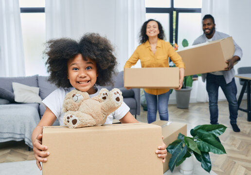 Happy African American family with cardboard boxes and things moves to a new home. Buying or renting a house for a young family