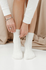 white knitted socks on female legs in the studio close-up