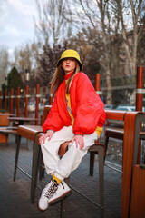 Teenager girl in colorful youth urban style clothes on city street
