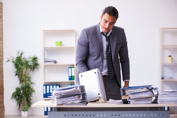 Young employee angry with excessive work holding knife