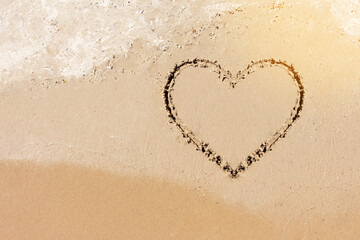 Heart drawn on the sea coast during daytime. Heart as a symbol of eternal love.