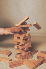 The child's hands pushed the brick and destroyed the tower. Janga wooden box. An imbalance....