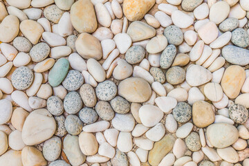 Stone pebbles texture background for interior exterior decoration. Natural nature pattern, pebbles under sunlight. Idyllic, relaxing round shaped background wallpaper