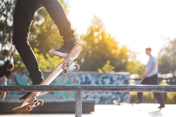 Teenage skateboarder sliding on rail in skatepark on sunny day – urban outdoor sport action