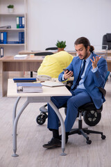 Young male employee looking after new born at workplace