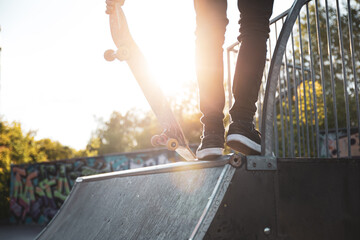 Skater standing on a ramp in skatepark in sunny day