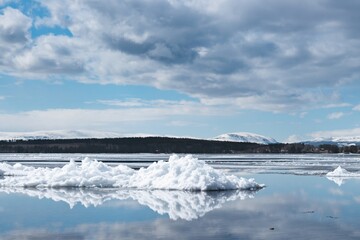 Melting snow on Lake Storsjön against the backdrop of the mountains near Andersön Island in Sweden