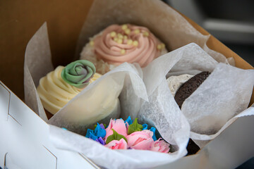 Fototapeta na wymiar Variety of delicious cupcakes in a box from a pastry shop