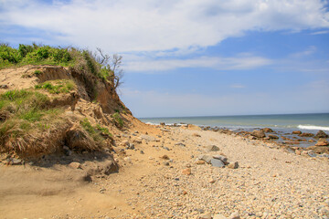 Beach with rocks and a sand dune near the ocean in summer