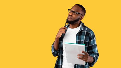 Thoughtful African Guy Thinking Holding Pen And Notebook, Studio Shot