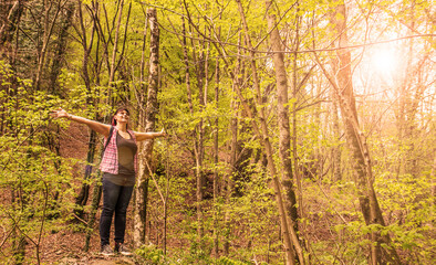 woman looks at the view from the tip of a boulder in the mountains