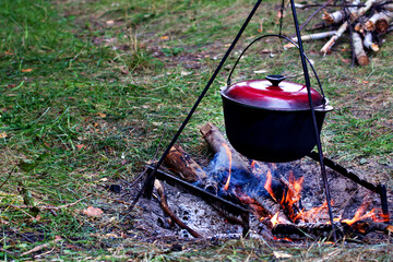 A pot over the fire. Summer vacation, hike, tourism - 436735299