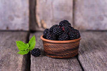 Fototapeta na wymiar Blackberries in a bowl on a wooden
