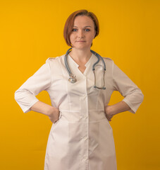 A female doctor stands with her hands in her hips. On a yellow background